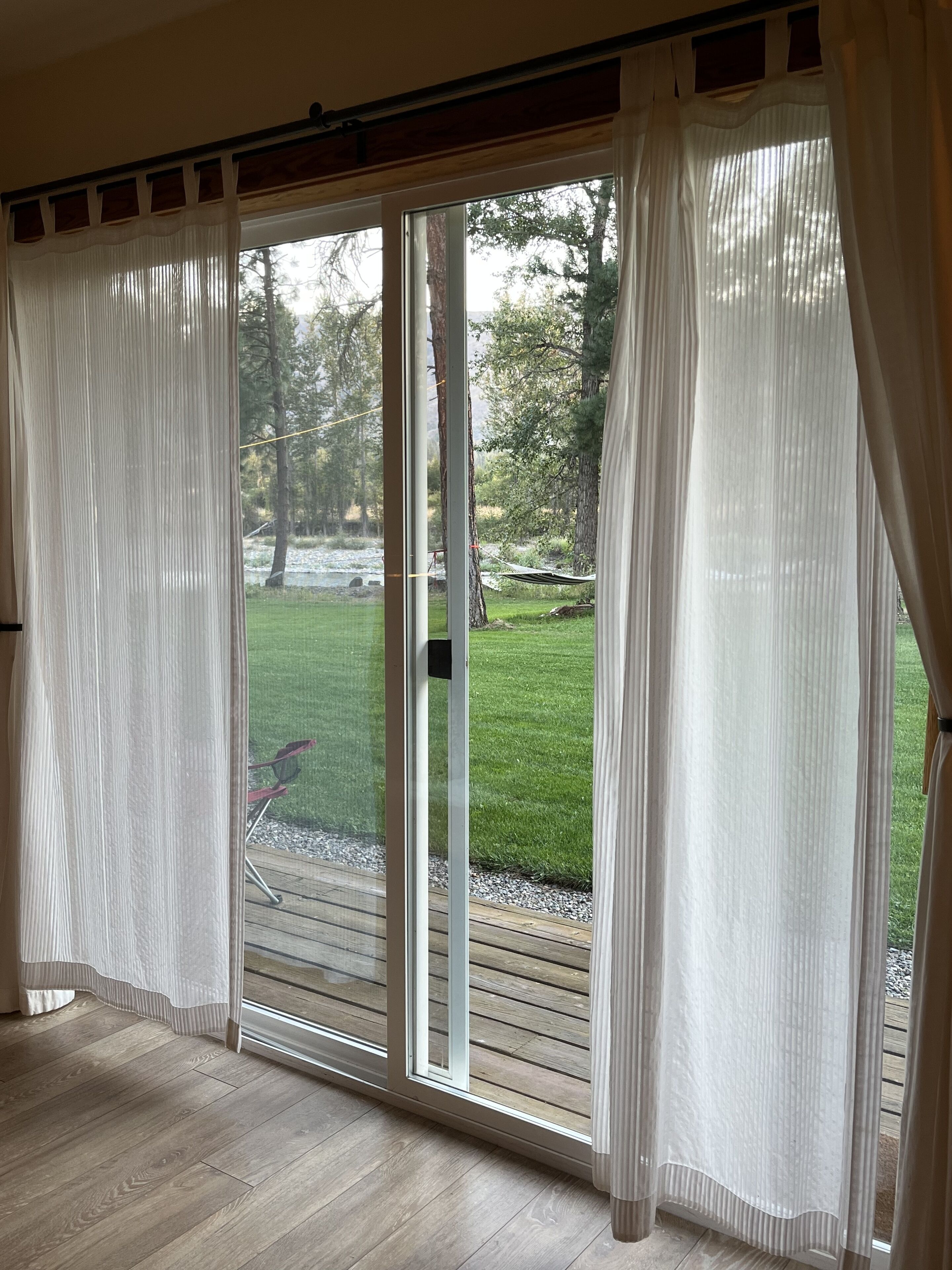 A room with a sliding glass door leading to a grassy outdoor area.