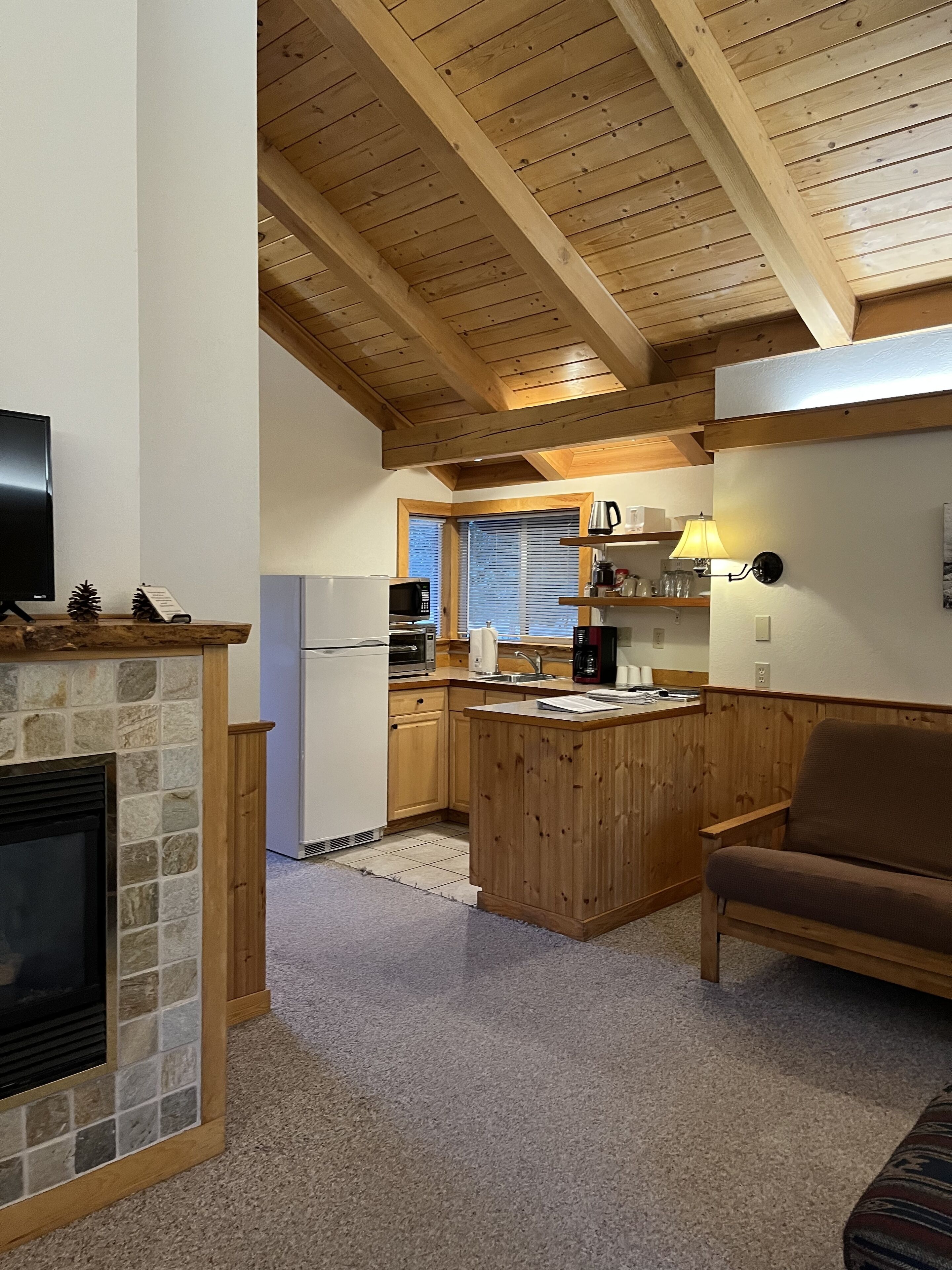 Une cuisine chaleureuse avec des poutres en bois, une cheminée en pierre et un mur en pierre.