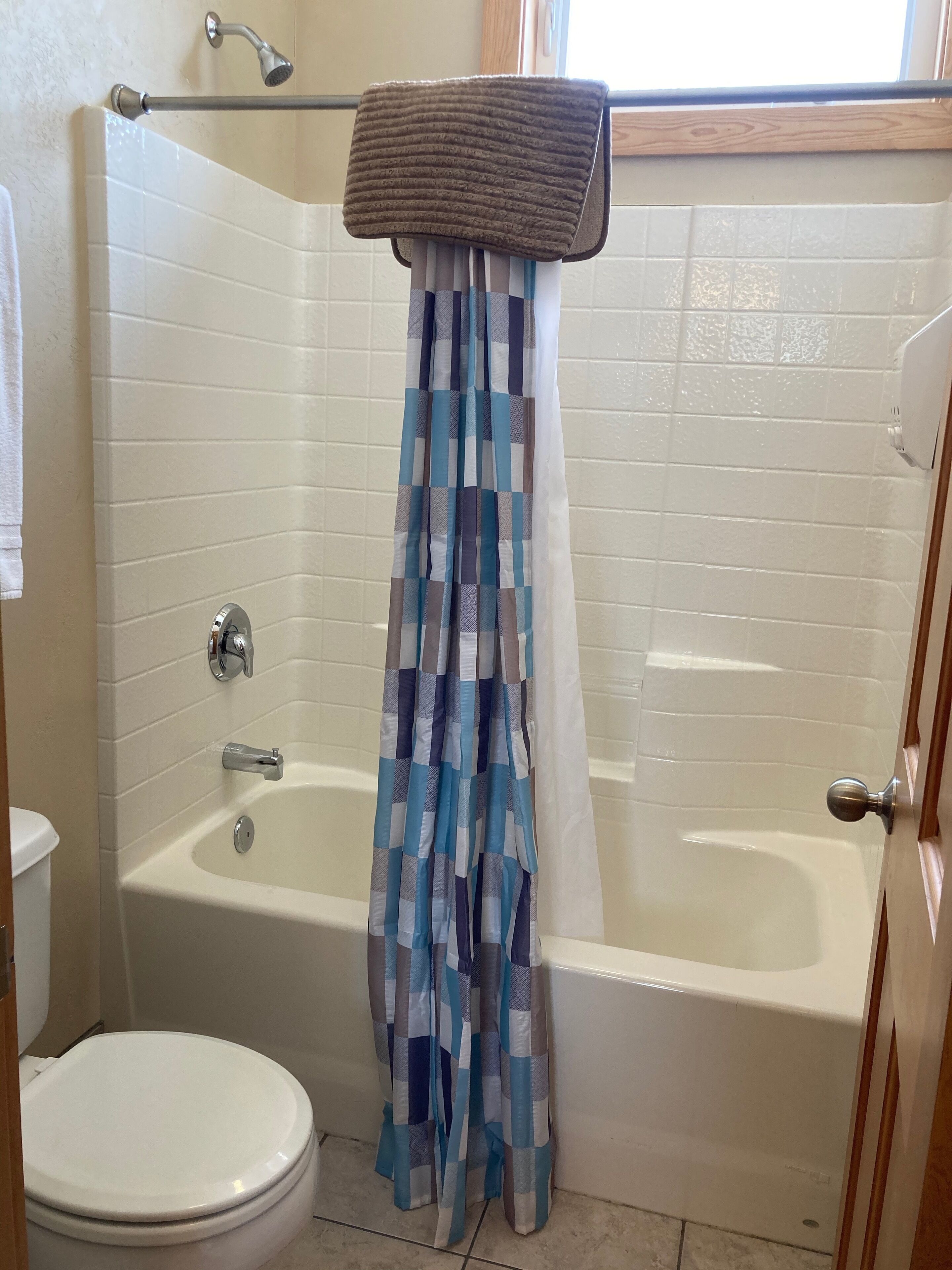 Ein Badezimmer mit Badewanne, Toilette und Duschvorhang.
