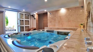 Une salle de bain moderne avec une grande baignoire, un sol en marbre et une fenêtre donnant sur un paysage verdoyant.