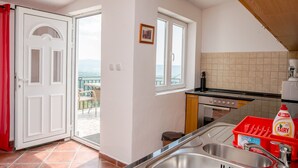 A kitchen with a sink, stove, and a view of the outdoors.