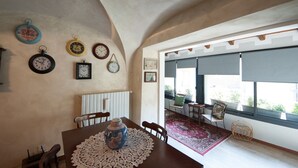 Un coin repas comprenant une table, des chaises, un vase et une horloge au mur.