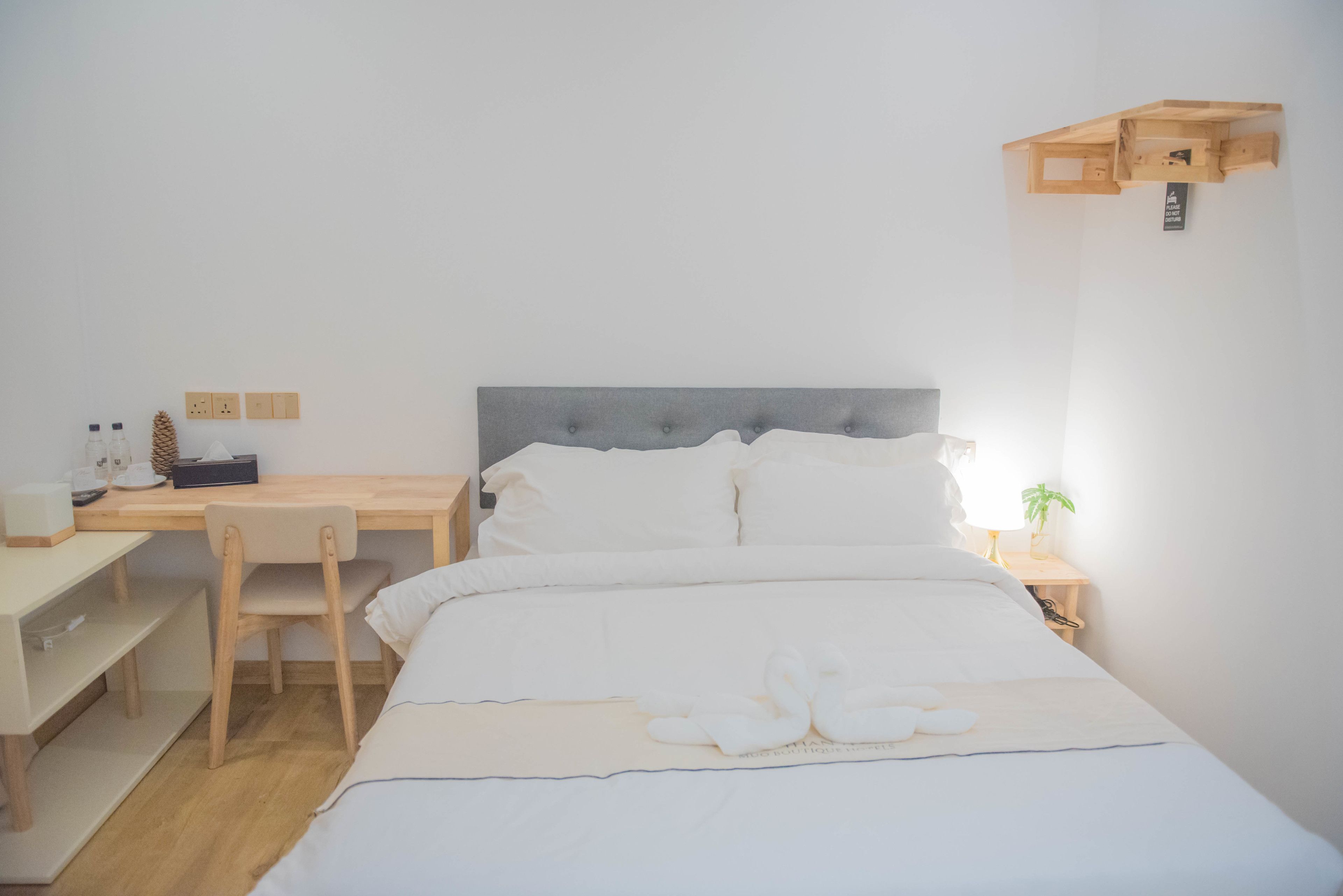 Un dormitorio ordenado con una cama, un escritorio y una silla.