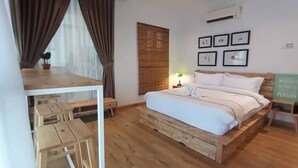 A bedroom with a wooden bed, a desk, and a ceiling fan. - MUO Resort (Muar)