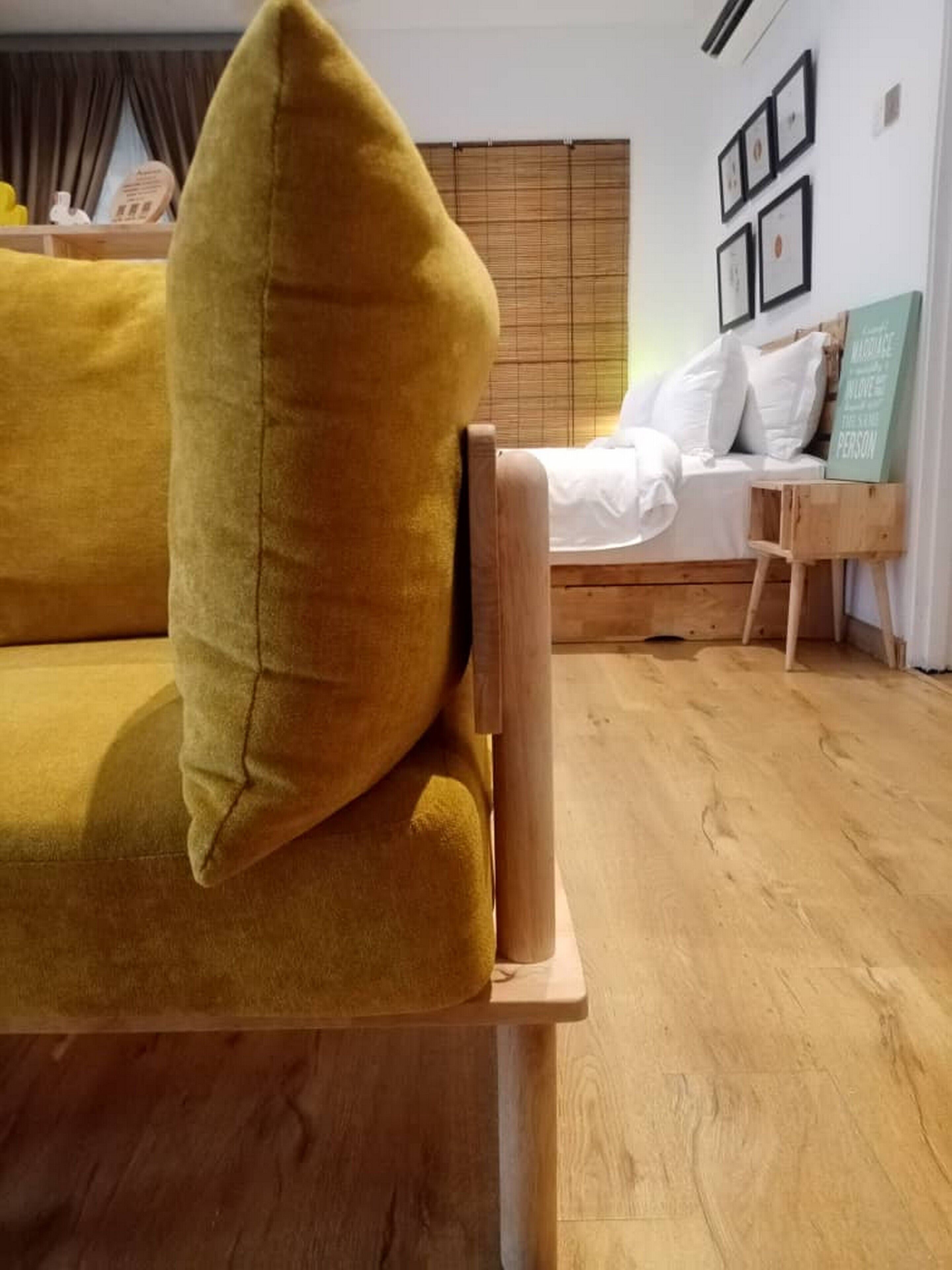 A room with a wooden bed, a yellow sofa, and a small wooden table.