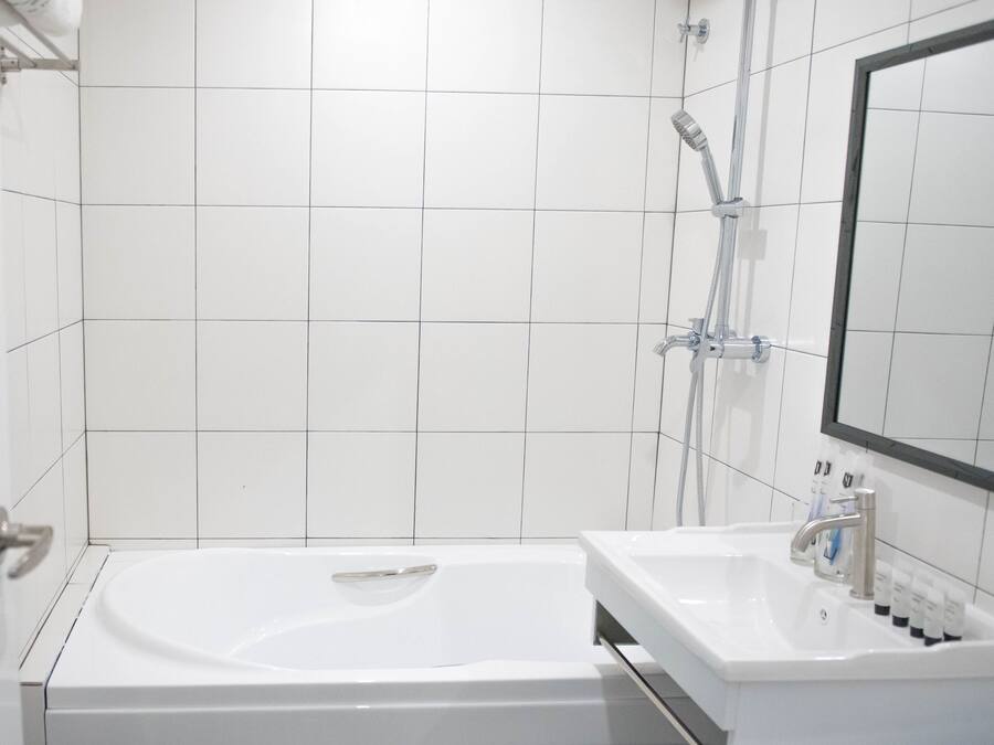 Un baño moderno con bañera, lavamanos y ducha.