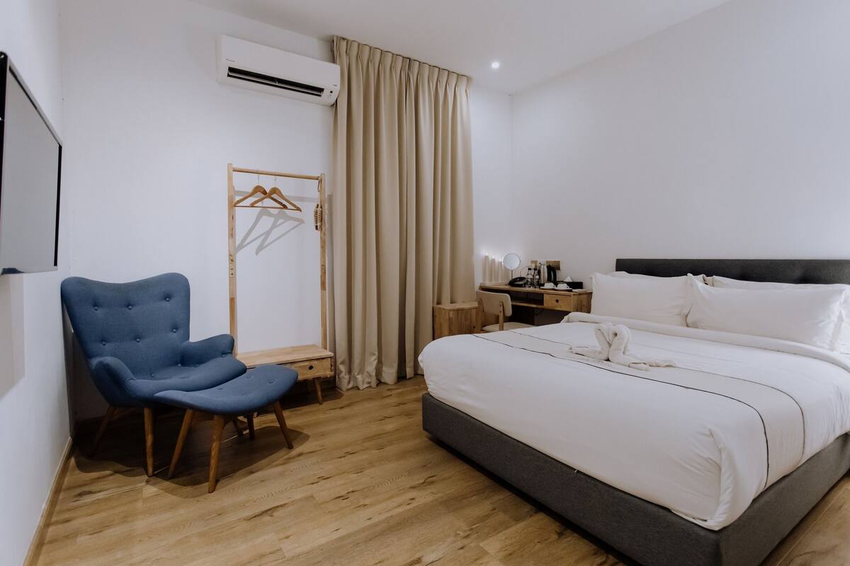 Ein Schlafzimmer mit Bett, Stuhl, Schreibtisch und Kleiderschrank.