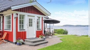 Une maison rouge et blanche avec vue sur un lac.