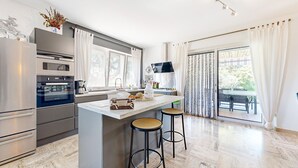 A modern kitchen with a central island, stainless steel appliances, and a view to a patio area. - Beautiful home in Lamotte Du Rhone (Lamotte Du Rhone)