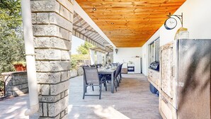 An outdoor patio with a brick wall, wooden ceiling, and a dining area with chairs and a table. - Beautiful home in Lamotte Du Rhone (Lamotte Du Rhone)