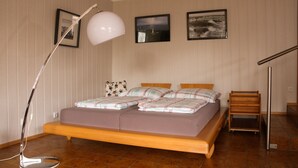 Una camera da letto con un letto, una lampada da terra e due quadri appesi al muro.
