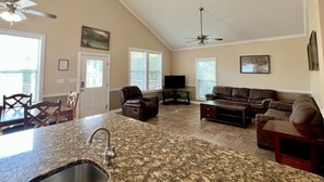 A spacious living area with a kitchen island, ceiling fans, and a large window. - "The Penthouse" #2 right on the Guadalupe, sleeps up to 15 people-private access (New Braunfels)