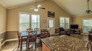 A spacious kitchen with a granite countertop, a dining area with wooden chairs, and a ceiling fan. - "The Penthouse" #2 right on the Guadalupe, sleeps up to 15 people-private access (New Braunfels)