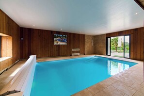An indoor swimming pool with wooden walls, a large window, and a painting. - Superb house with indoor pool in Burgundy- 16 people (argilly)