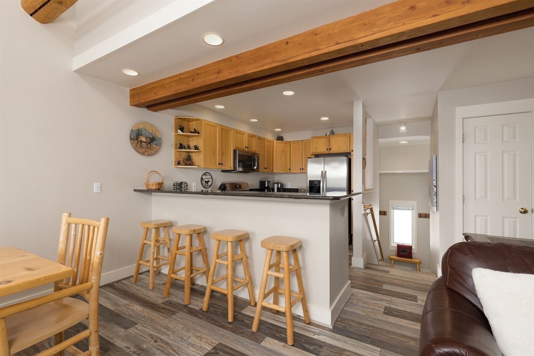 Eine moderne Küche mit Holzausstattung, einer zentralen Kochinsel und einer Essecke mit Holzstühlen.