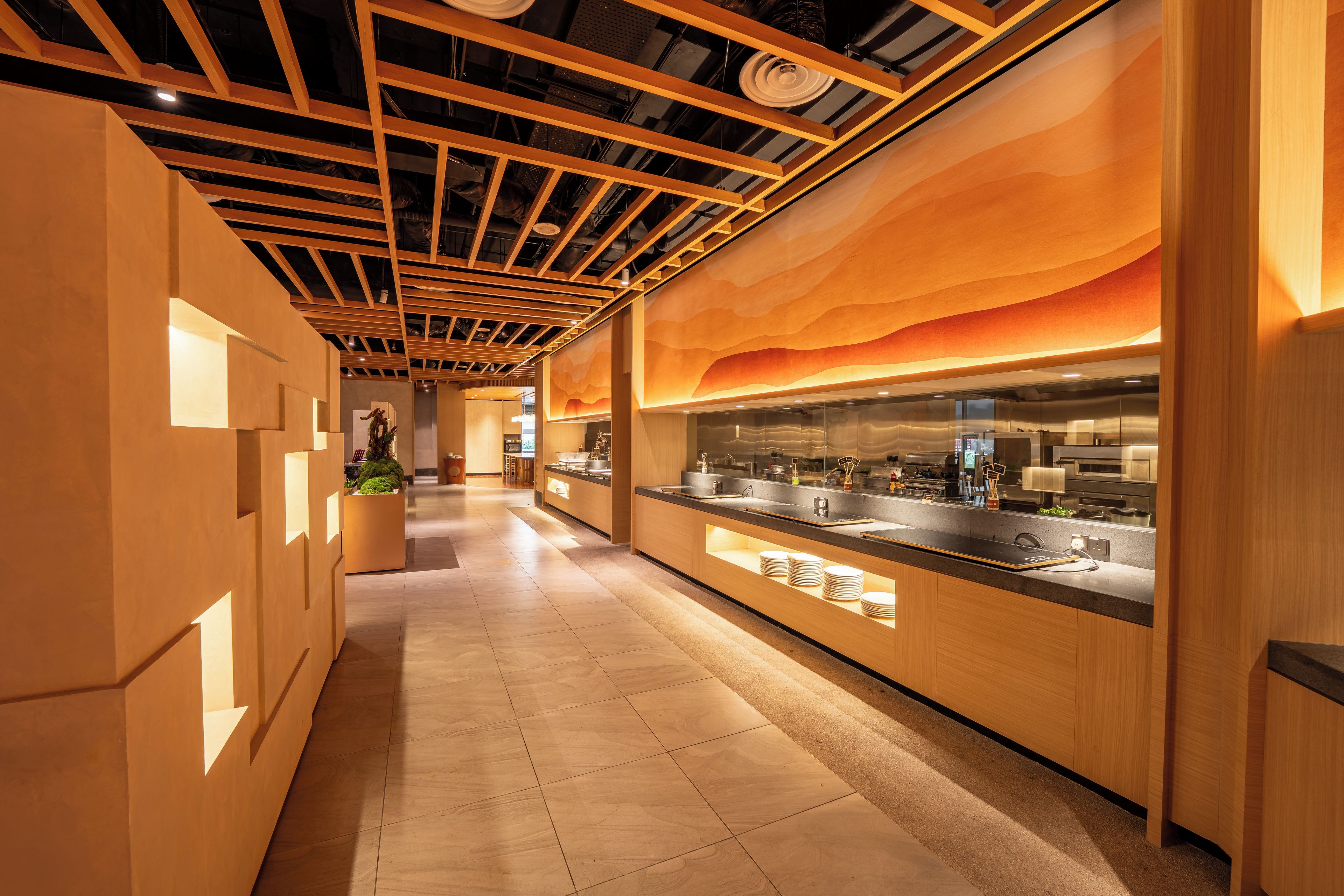 A modern kitchen with wooden cabinetry and a long countertop.