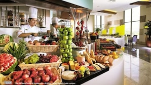 A buffet with various fruits and cheeses, chefs preparing food, and a modern hotel interior. - St. Giles Mid Valley Kuala Lumpur (Kuala Lumpur)