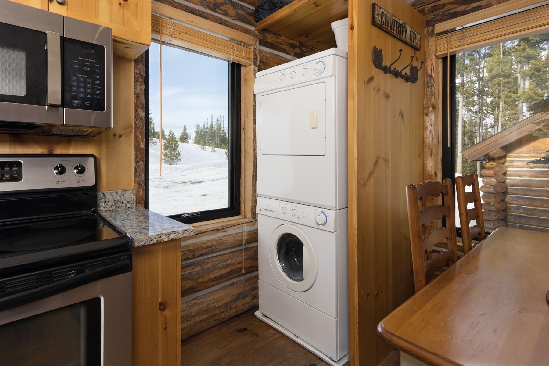 A compact kitchen with a microwave, stove, and washing machine.