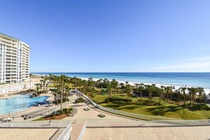 Ein Resort mit Pool, Strand und Palmen.