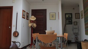 A dining area with a skylight, a wooden door, and a wall with framed pictures. - Situada dentro de um condomínio fechado de luxo, com a praia a 3 minutos a pé (Porto Santo)