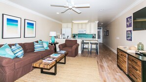 A modern living room with a brown sofa, a wooden coffee table, and a ceiling fan. - H-G-T-V type Renovation, Million Dollar view starting at only $210/night! (Kapaa)