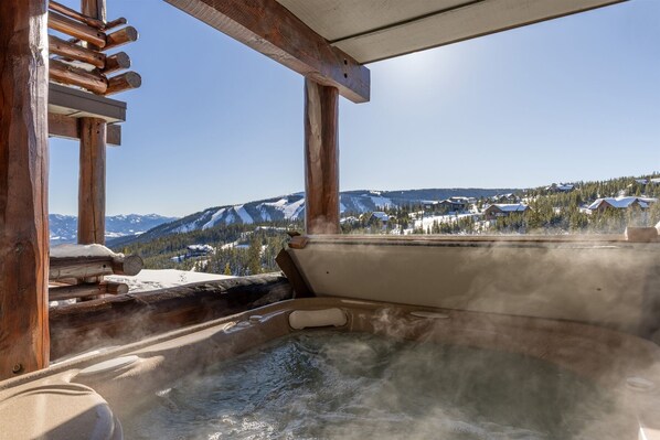 Relax in a serene hot tub with a panoramic view of the surrounding mountains.
