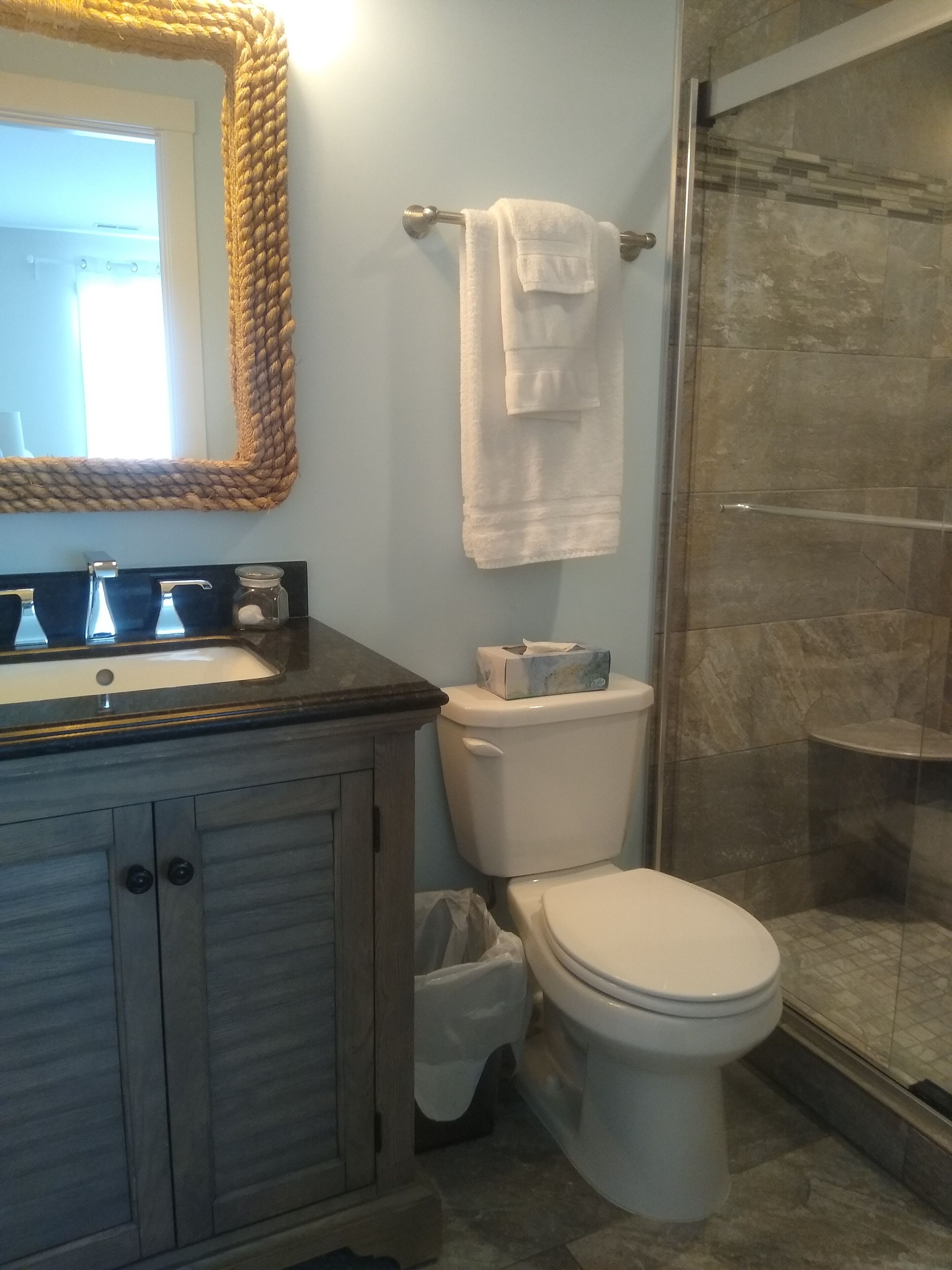 A bathroom with a toilet, sink, and shower.
