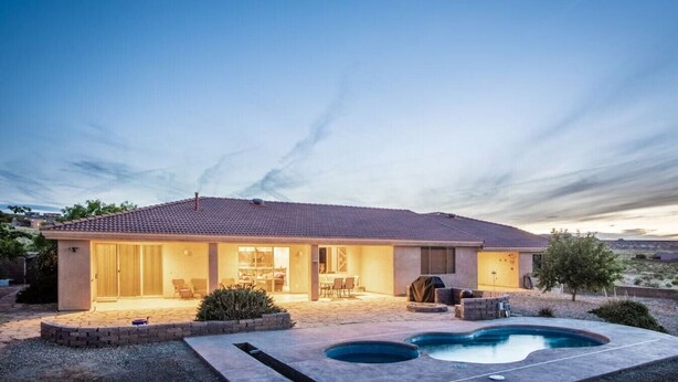 Uma casa de dois andares com um pátio e uma piscina.