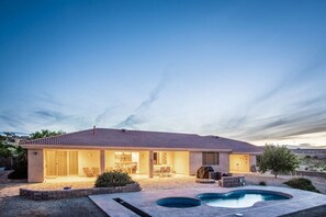 Une maison à deux étages avec une terrasse et une piscine.