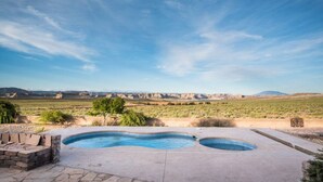 Piscina com vista para paisagem desértica e montanhas ao fundo.