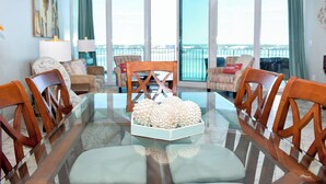 A dining area with a glass table, wooden chairs, and a decorative centerpiece.
