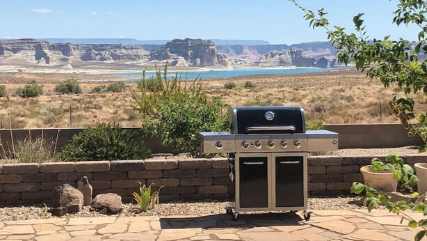 Ein Grillplatz in einer angelegten Außenanlage mit Blick auf eine Schlucht und einen See.