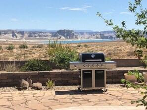 A barbecue grill in a landscaped outdoor area with a view of a canyon and a lake. - NIZHONI Pool, Hot Tub & 10 Minutes To Lake Powell - 125.00 credit off 4th night! (Greenehaven)