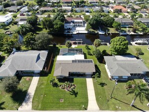 Vue aérienne d’un quartier résidentiel avec des maisons, une piscine et un quai.