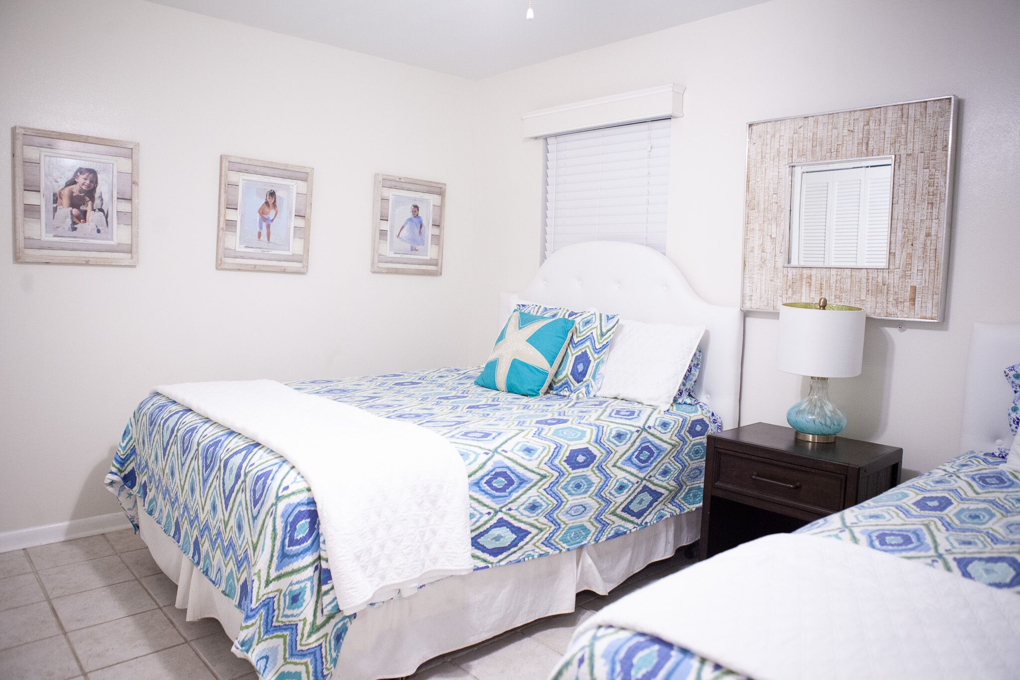 A bedroom with a bed, a nightstand, and a wall-mounted lamp.
