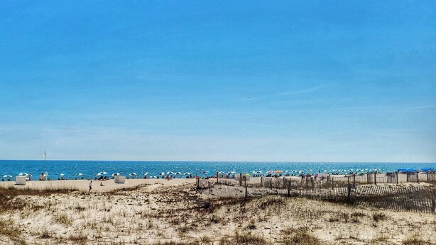 Una platja amb un cartell que diu 'LEAVE ONLY FOOTPRINTS'.