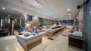 Een modern restaurant met een centraal eiland, eettafels en een buffetgedeelte.