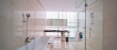 Un baño moderno con cabina de ducha de vidrio, una bañera independiente y un lavabo con espejo.