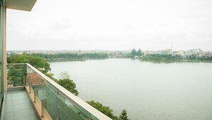 Uitzicht vanaf een balkon op een rivier, met gebouwen in de verte.