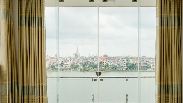Uitzicht vanaf een balkon, met een stadsbeeld en water op de achtergrond.