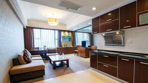 Een moderne hotelkamer met een zithoek, een keuken en een eethoek.