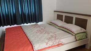 A bed with a white headboard, a red blanket, and decorative pillows. - Family Homestay Melody Vung Tau (Ho Chi Minh City)