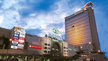 A hotel with a prominent 'Mid Valley' sign, surrounded by various commercial buildings and a large digital billboard.
