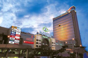 Un hôtel reconnaissable à son grand panneau indiquant « Mid Valley », entouré de divers immeubles commerciaux et d’un grand panneau d’affichage numérique.