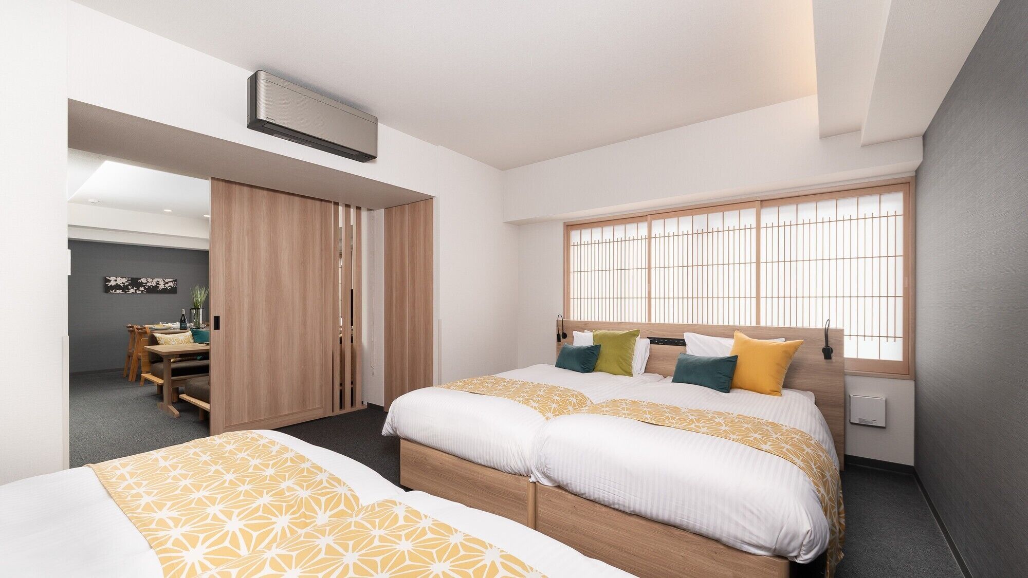 A hotel room with a bed, a window with a view, a desk, and a wardrobe.