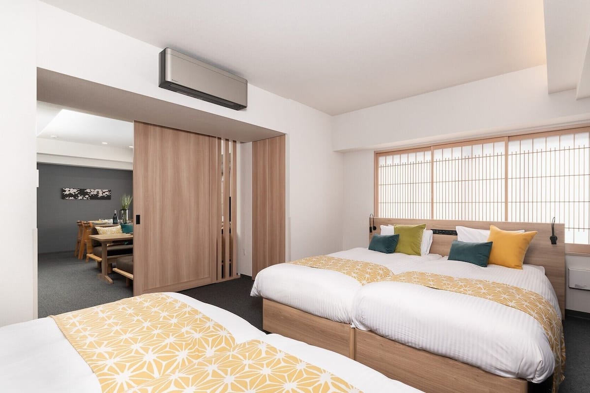 A hotel room with a bed, a window with a view, a desk, and a wardrobe.