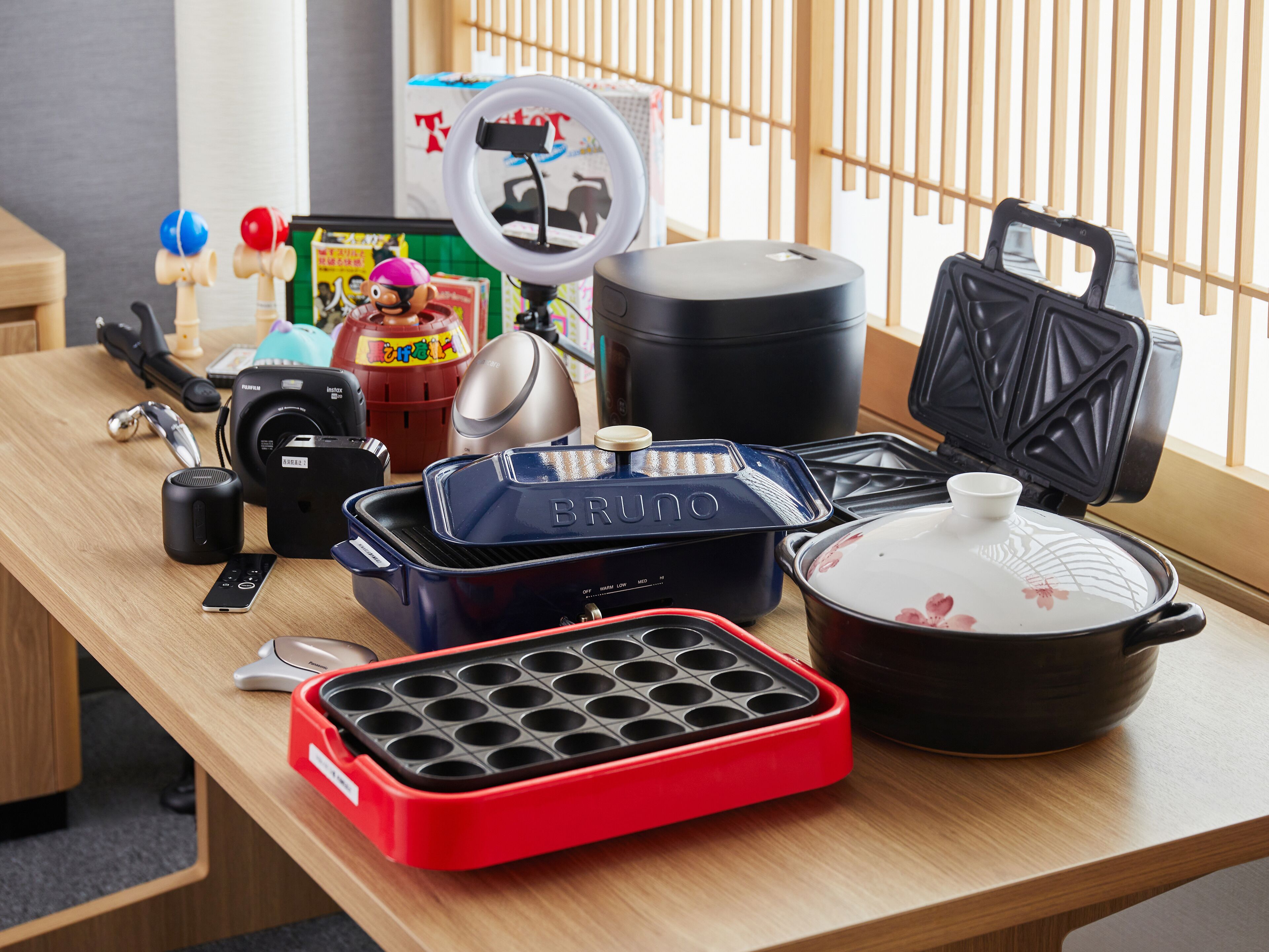 A kitchen counter with various appliances including a waffle maker, a rice cooker, and a portable heater.
