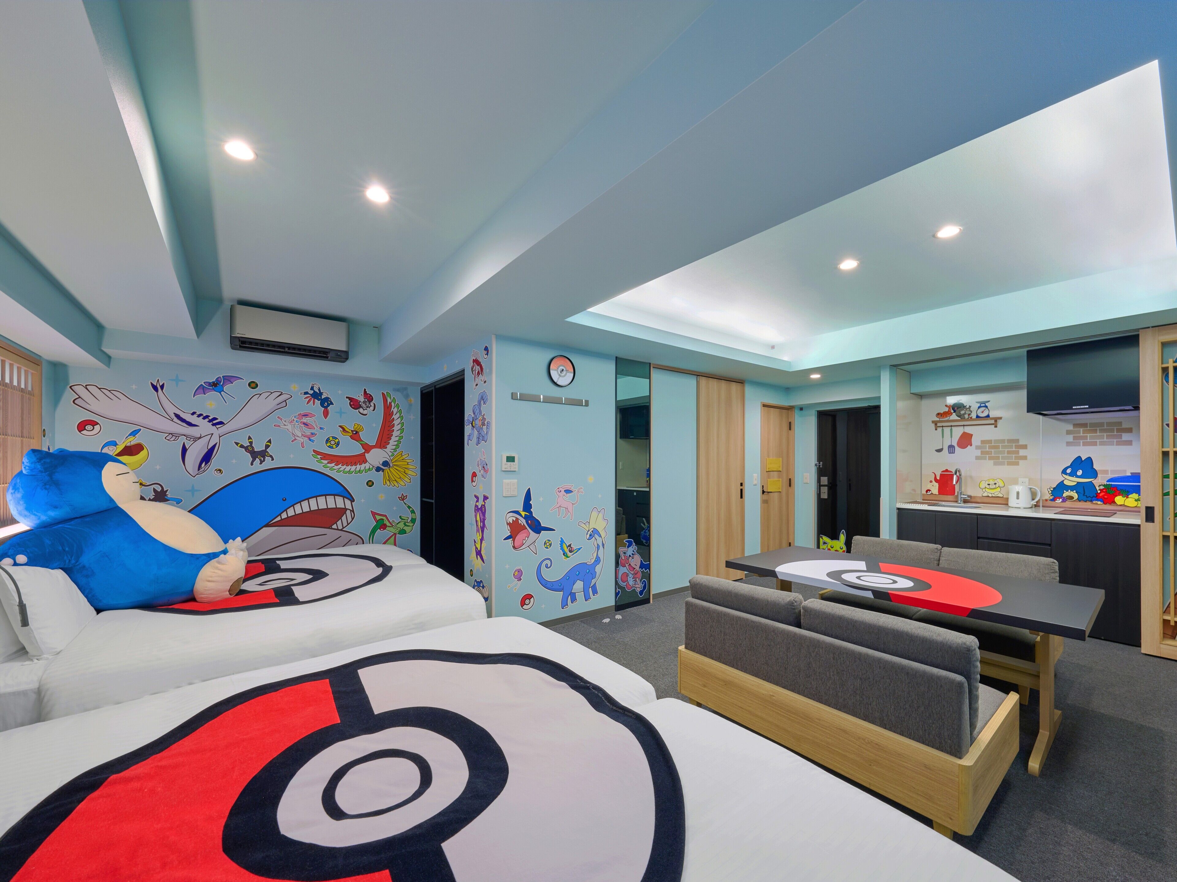 Una habitación de hotel con una cama grande, una mesa de comedor y una kitchenette.