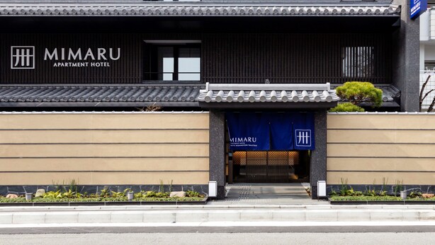 Un bâtiment moderne avec une enseigne indiquant « MIMARU APARTMENT HOTEL ».