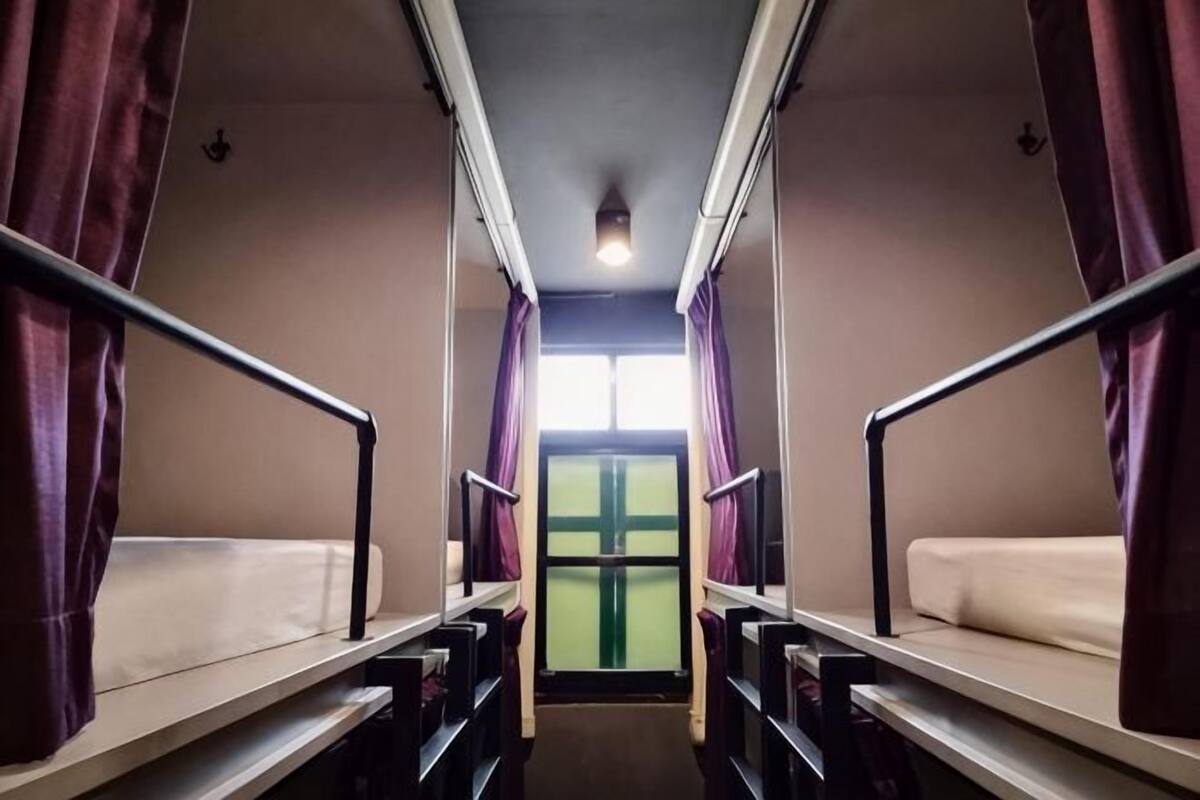 A train compartment with two berths, each with a mattress and a headboard.